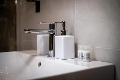 a bathroom sink with a faucet and two rolls of paper towels at ht vittorio in Rome