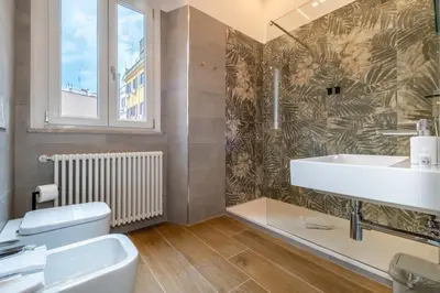 a bathroom with a toilet and a sink and a window at ht vittorio in Rome