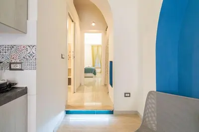 a hallway of a home with a blue and white wall at lollo's home in Rome