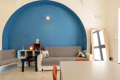 a living room with a couch and a blue wall at lollo's home in Rome