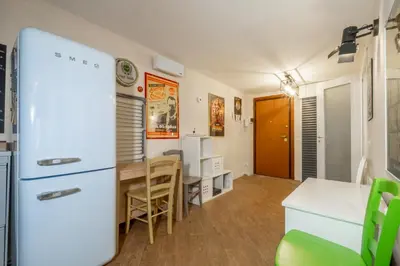 a kitchen and dining room with a refrigerator and a table at ht movie flat bilo in Rome