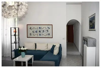 a living room with a blue couch and a chandelier at Raffa al Pigneto in Rome