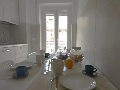 a white kitchen with an orange on a table at Rome sweet home - Casa Cesari in Rome
