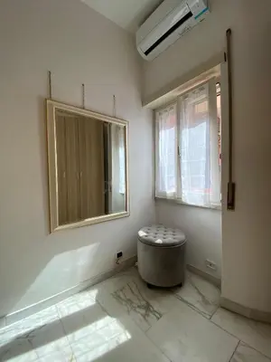 a room with a window and a ottoman in the corner at Ripa di Trastevere in Rome