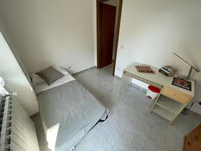 a small bedroom with a bed and a desk at Casa cozy e luminosa - Tiburtina in Rome