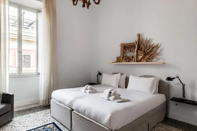 a bedroom with a large white bed with towels on it at Nauta Rome - Comfort e Design in Rome