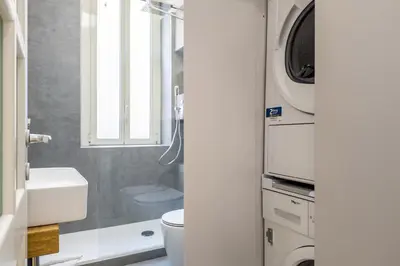 a bathroom with a sink and a washing machine at Nauta Rome - Comfort e Design in Rome