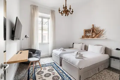 a bedroom with two beds and a desk and a tv at Nauta Rome - Comfort e Design in Rome