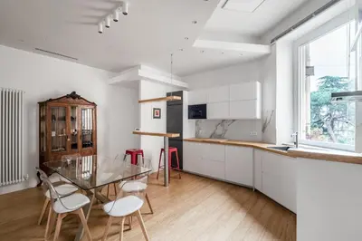 a kitchen with a glass table and white cabinets at Nauta Rome - Comfort e Design in Rome