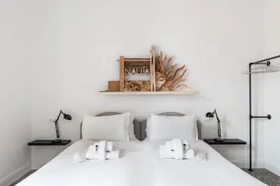 a bedroom with a white bed with two lamps at Nauta Rome - Comfort e Design in Rome
