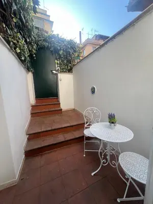 a patio with two tables and a table and chairs at Cupola Rooms Vicino al Vaticano in Rome