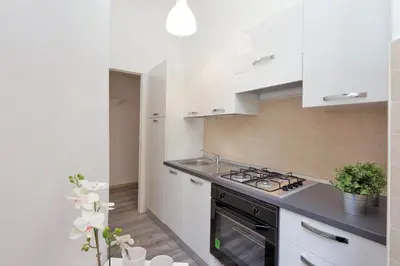 a kitchen with white cabinets and a stove top oven at DaliTourism - Colosseo Experience 28 in Rome