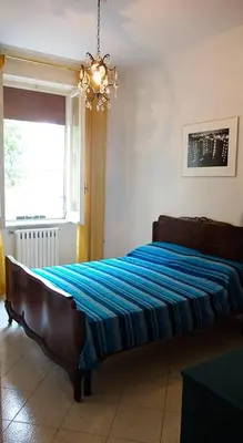 a bedroom with a bed with a blue striped blanket at Casa GattaMelata in Rome