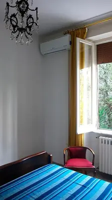 a bedroom with a bed and a window and a chandelier at Casa GattaMelata in Rome