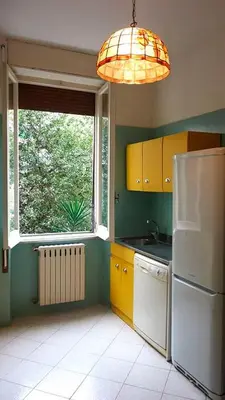 a kitchen with a white refrigerator and a window at Casa GattaMelata in Rome