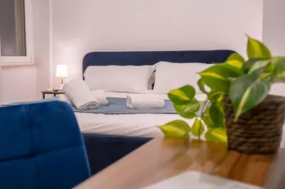 a blue bed with a blue couch and a table at Pallaro 6 room in Rome