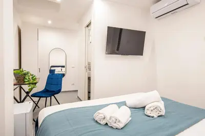a bedroom with a bed and a tv and a chair at Pallaro 6 room in Rome