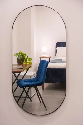 a mirror with a blue chair and a bed at Pallaro 6 room in Rome