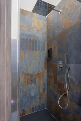 a bathroom with a shower with a glass door at Aurelia Garden Suite in Rome
