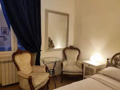 a bedroom with two chairs and a table and a bed at Azzurra Home in Rome