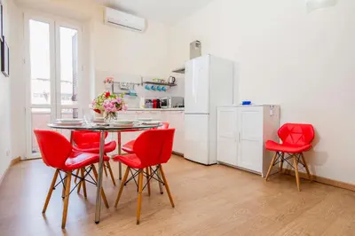 a kitchen with a table and red chairs in a room at Azzurra Home in Rome