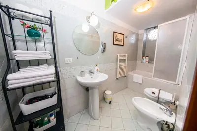 a white bathroom with a sink and a mirror at Azzurra Home in Rome