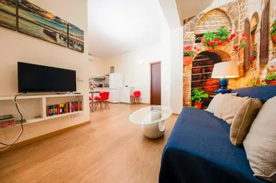a living room with a blue couch and a tv at Azzurra Home in Rome