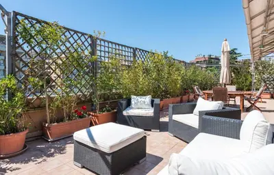 a patio with chairs and tables and plants at Vatican-Metro A Panoramic Penthouse with Jacuzzi in Rome