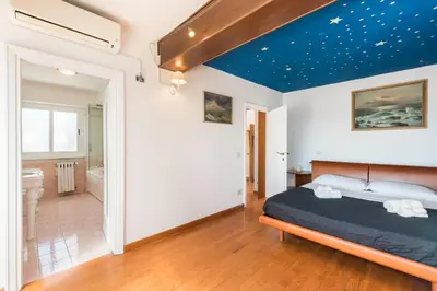 a bedroom with a bed with a blue ceiling at Vatican-Metro A Panoramic Penthouse with Jacuzzi in Rome