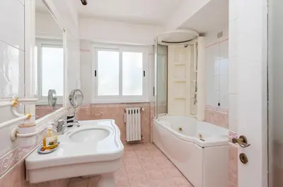a bathroom with a sink and a tub and a toilet at Vatican-Metro A Panoramic Penthouse with Jacuzzi in Rome