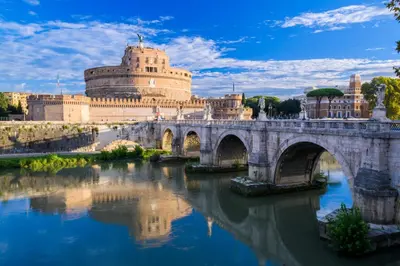 a bridge over a river in front of a building at Vatican-Metro A Panoramic Penthouse with Jacuzzi in Rome