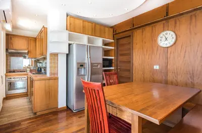 a kitchen with a wooden table and a clock on the wall at Vatican-Metro A Panoramic Penthouse with Jacuzzi in Rome