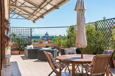 a patio with an umbrella and a table and chairs at Vatican-Metro A Panoramic Penthouse with Jacuzzi in Rome