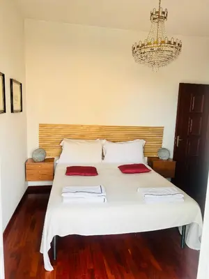 a bedroom with a large white bed with a chandelier at I Gerani in Rome