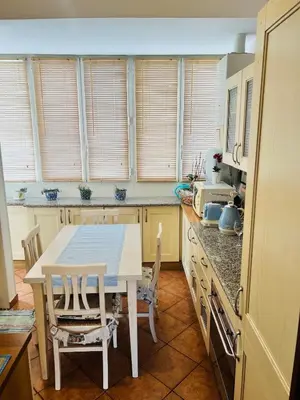 a kitchen with a table and chairs and windows at I Gerani in Rome