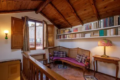 a living room with a couch and shelves with books at Terrazza Altavista - Aeternum Urbe in Rome