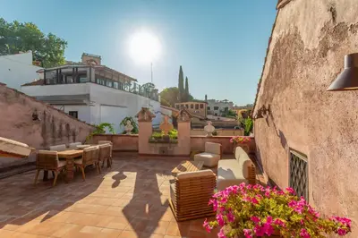an outdoor patio with chairs and tables and flowers at Terrazza Altavista - Aeternum Urbe in Rome