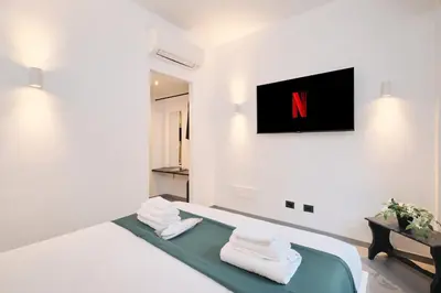 a room with a bed with a n on the wall at Vatican Charming Retreat by NDP rent in Rome