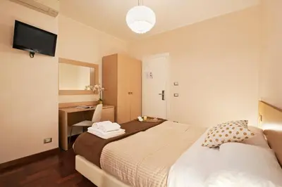 a bedroom with a bed and a desk and a television at La Piccola Maison in Rome