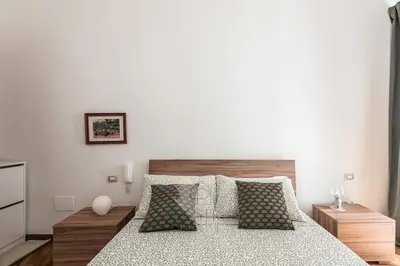 a bedroom with a large bed with white walls at Vatican Gallery Apartment in Rome