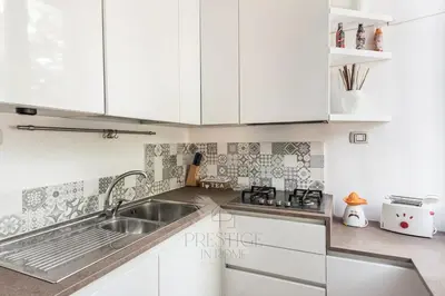 a kitchen with white cabinets and a sink at Vatican Gallery Apartment in Rome