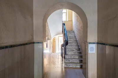 a hallway with an archway and stairs in a building at Vatican Gallery Apartment in Rome
