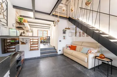 a living room with a couch and a staircase at Suede Loft Retreat, Charm, Relax Private Parking in Rome