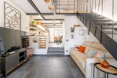 a living room with a couch and a staircase at Suede Loft Retreat, Charm, Relax Private Parking in Rome