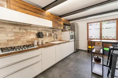 a kitchen with white cabinets and a brick wall at Suede Loft Retreat, Charm, Relax Private Parking in Rome
