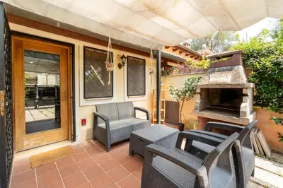 a patio with chairs and a fireplace on a house at Suede Loft Retreat, Charm, Relax Private Parking in Rome