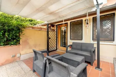 a patio with chairs and a table and a porch at Suede Loft Retreat, Charm, Relax Private Parking in Rome