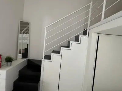 a staircase in a living room with a mirror at Vacanze Romane in Rome