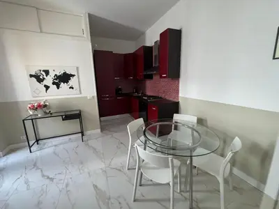 a dining room with a glass table and white chairs at Vacanze Romane in Rome