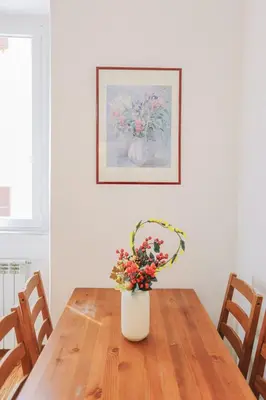 a vase with flowers sitting on a wooden table at Casa Pan in Rome